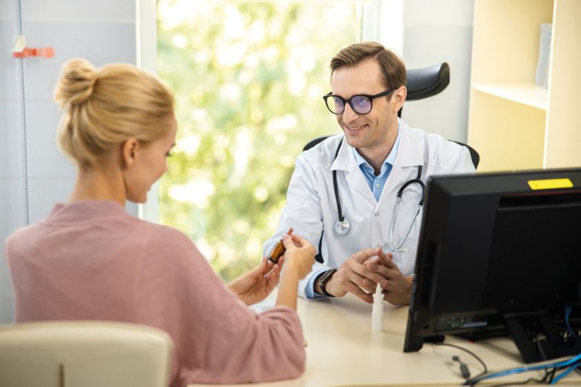 Joyful therapist prescribing treatment for female stock photo